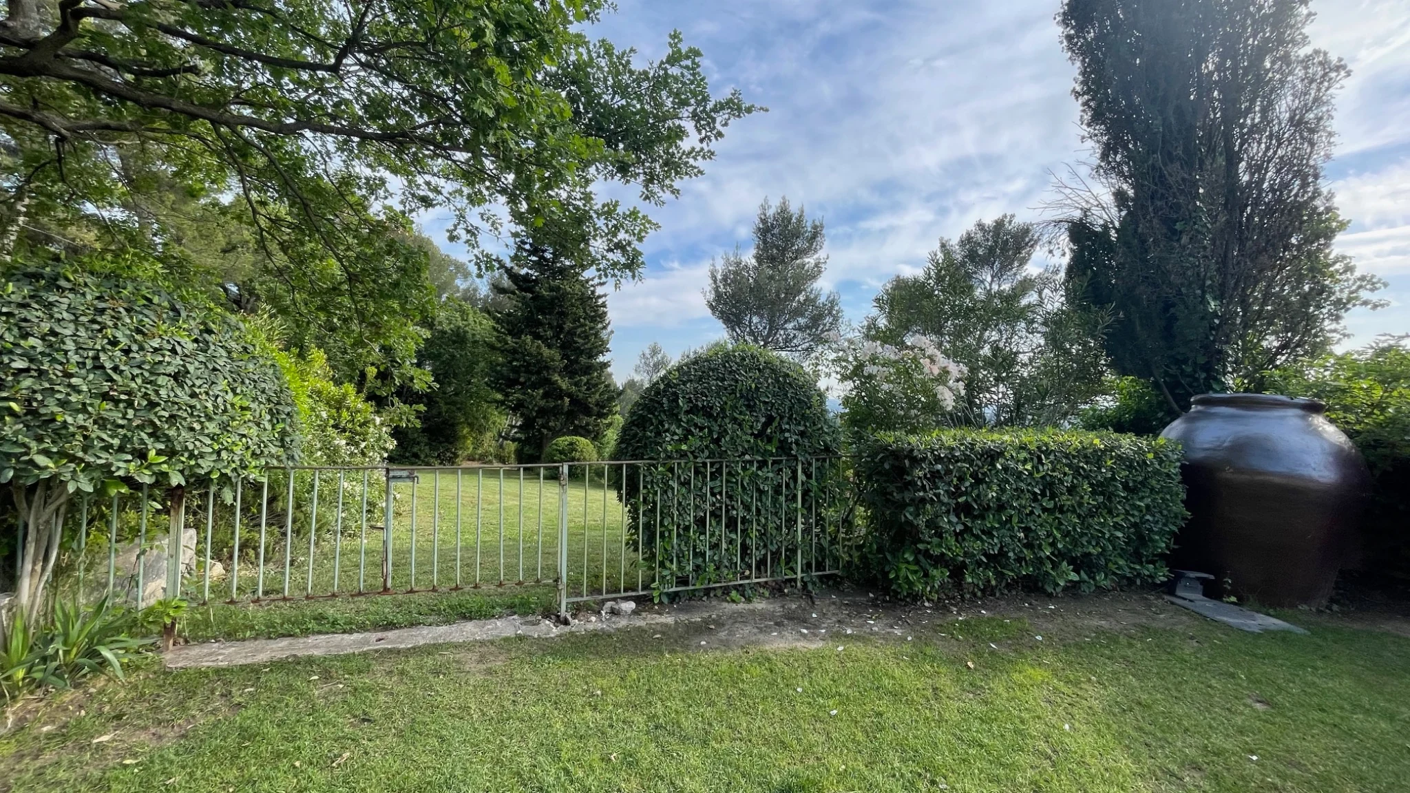 Jardin structuré avec portail et végétation taillée